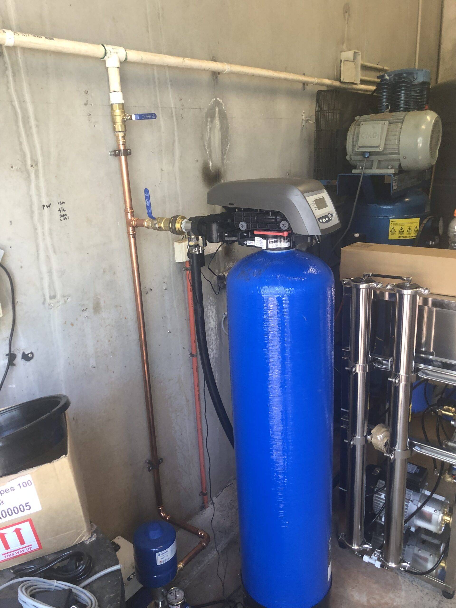 Water filtration system installation with blue tank in Brisbane home